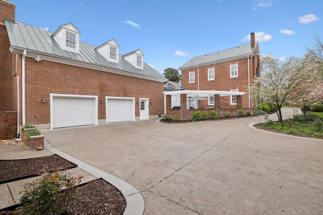 224 3rd Ave S, Franklin, TN 37064 - view of property exterior with a standing seam roof, driveway, brick siding, and metal roof