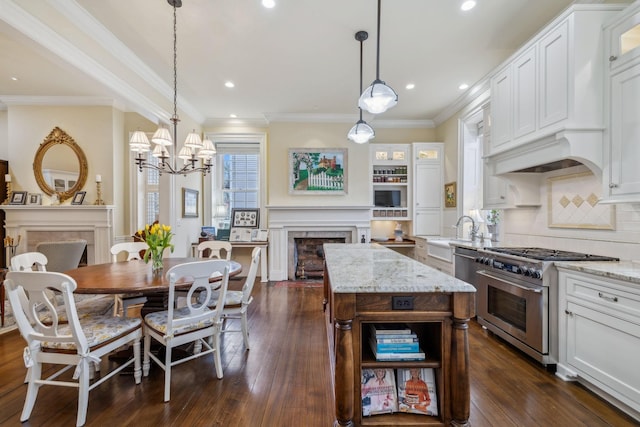 224 3rd Ave S, Franklin, TN 37064 - kitchen featuring stainless steel stove, a fireplace, a chandelier, dark wood-style floors, and recessed lighting
