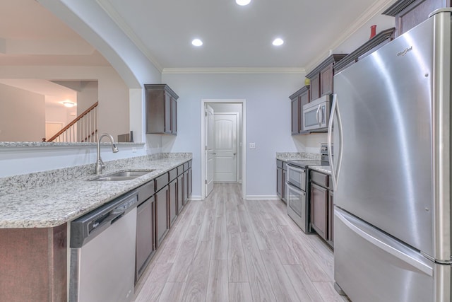 5115 Heroes Ln, Murfreesboro, TN 37129 - kitchen featuring stainless steel appliances, a sink, arched walkways, light stone counters, and dark brown cabinets