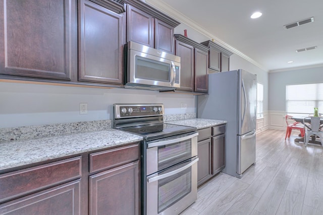 5115 Heroes Ln, Murfreesboro, TN 37129 - kitchen featuring appliances with stainless steel finishes, ornamental molding, light wood-style flooring, wainscoting, and dark brown cabinetry