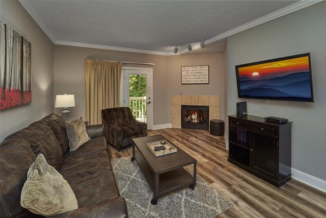 818 Golf View Blvd Unit 1303, Pigeon Forge, TN 37863 - living room featuring rail lighting, wood finished floors, ornamental molding, baseboards, and a tiled fireplace