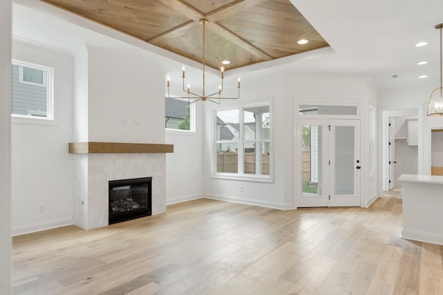 3150 Long Branch Cir, Franklin, TN 37064 - unfurnished living room with a chandelier, light wood-type flooring, a glass covered fireplace, recessed lighting, and baseboards