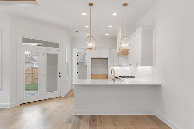 3150 Long Branch Cir, Franklin, TN 37064 - kitchen with a peninsula, decorative backsplash, light countertops, white cabinetry, and a chandelier