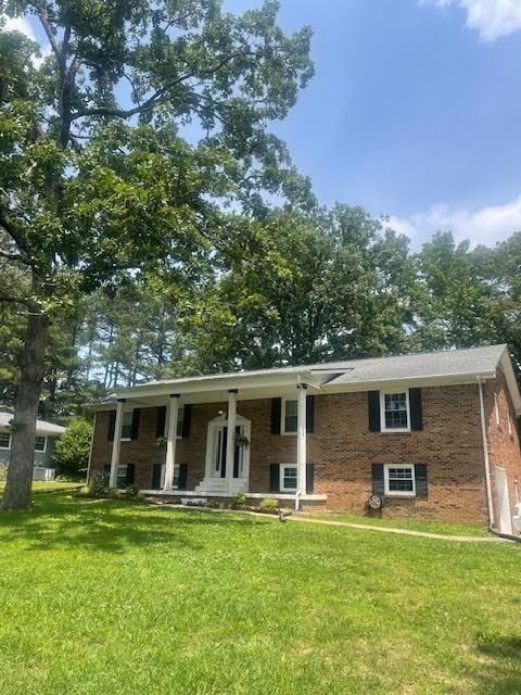 1704 Deer Hollow Dr W, Lawrenceburg, TN 38464 - bi-level home with covered porch, a front yard, and brick siding
