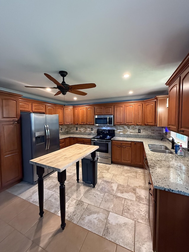 1704 Deer Hollow Dr W, Lawrenceburg, TN 38464 - kitchen featuring stainless steel appliances, a ceiling fan, tasteful backsplash, light stone countertops, and brown cabinets