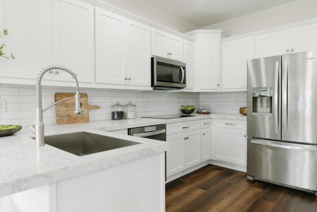 307 Fletcher Ct, Franklin, TN 37067 - kitchen featuring appliances with stainless steel finishes, a sink, crown molding, white cabinets, and tasteful backsplash