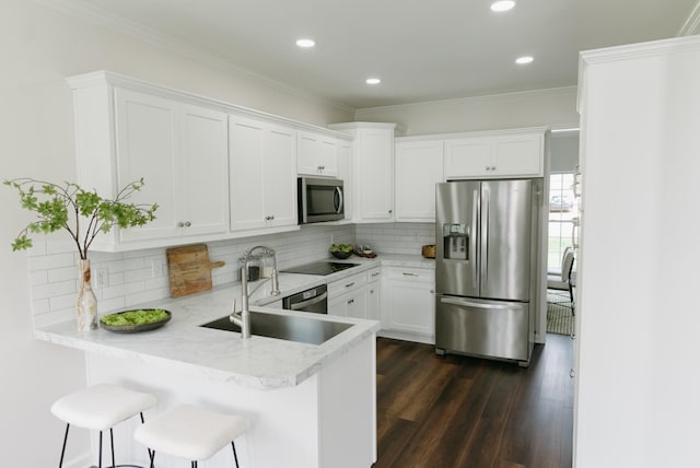 307 Fletcher Ct, Franklin, TN 37067 - kitchen featuring appliances with stainless steel finishes, a sink, a peninsula, white cabinets, and crown molding