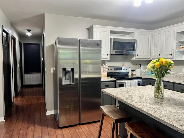 831 Harris Rd, Dickson, TN 37055 - kitchen featuring stainless steel appliances, open shelves, a breakfast bar area, white cabinets, and wood-type flooring