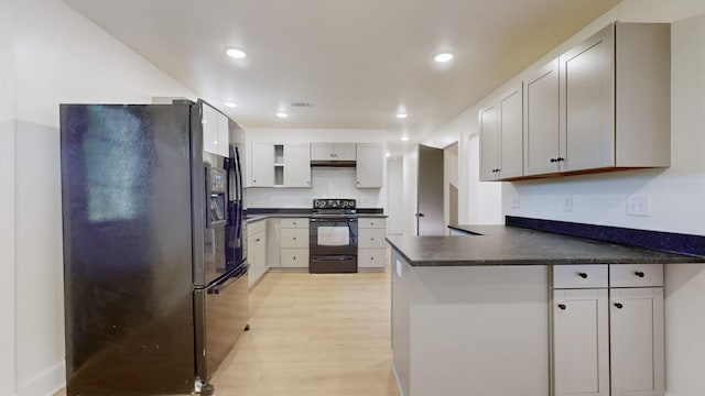 110 Lynn Ln, Old Hickory, TN 37138 - kitchen featuring black appliances, a peninsula, dark countertops, light wood-type flooring, and recessed lighting