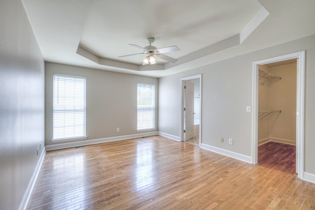 1030 Meandering Way, Franklin, TN 37067 - unfurnished bedroom with a raised ceiling, light wood finished floors, and baseboards