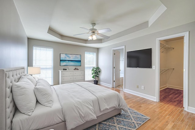 1030 Meandering Way, Franklin, TN 37067 - bedroom with a raised ceiling, multiple windows, baseboards, and light wood-style flooring