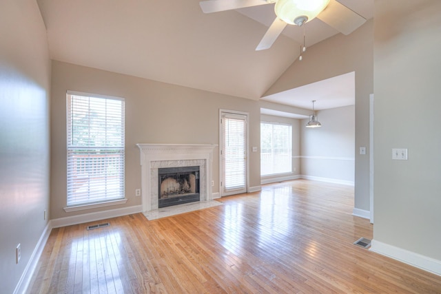 1030 Meandering Way, Franklin, TN 37067 - unfurnished living room with vaulted ceiling, light wood-style floors, a premium fireplace, a ceiling fan, and baseboards