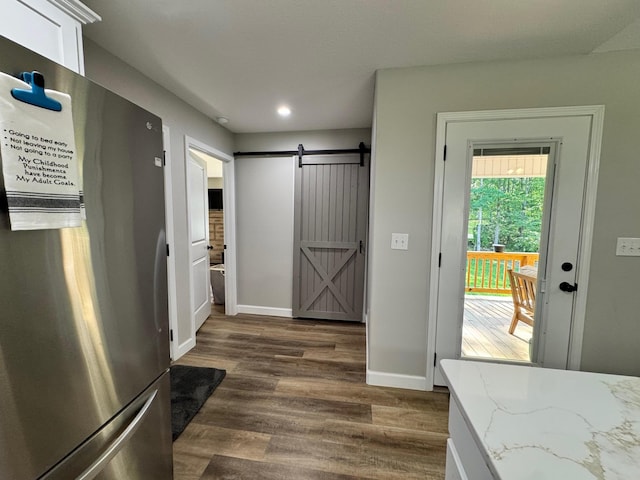 111 Stellar Ct, Clarkrange, TN 38553 - kitchen with freestanding refrigerator, a barn door, dark wood-style flooring, baseboards, and light stone counters