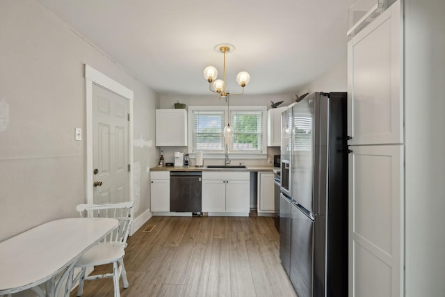 807 Brown St, Columbia, TN 38401 - kitchen with stainless steel appliances, white cabinets, a sink, light wood-style flooring, and a chandelier