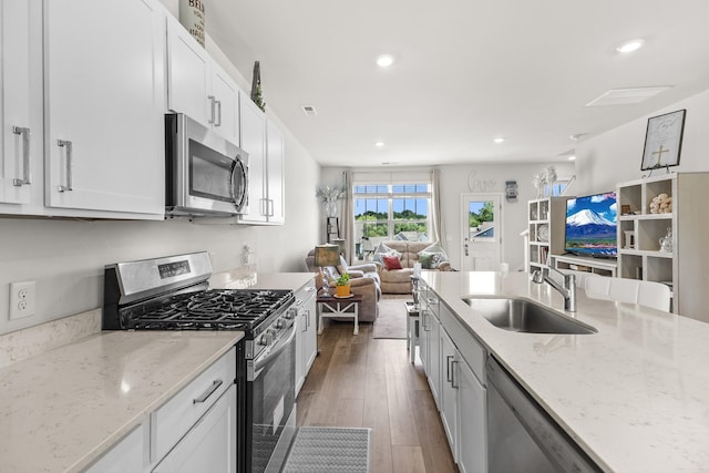 2563 Drumwright Way, Columbia, TN 38401 - kitchen with stainless steel appliances, a sink, open floor plan, dark wood finished floors, and white cabinetry