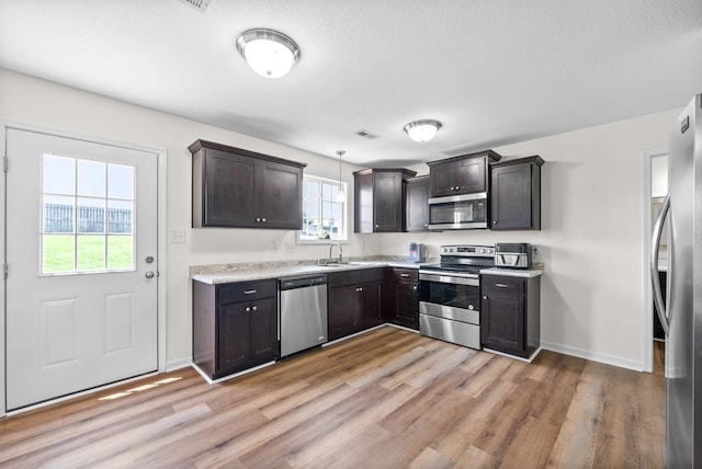 157 Bob White Trl, Oak Grove, KY 42262 - kitchen featuring stainless steel appliances, a sink, light wood finished floors, light countertops, and baseboards