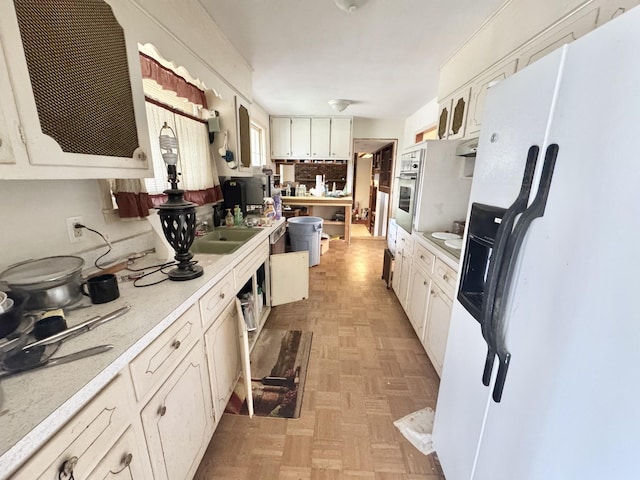 345 Lockert Pl, Clarksville, TN 37043 - kitchen featuring white refrigerator with ice dispenser, light countertops, white cabinetry, and glass insert cabinets