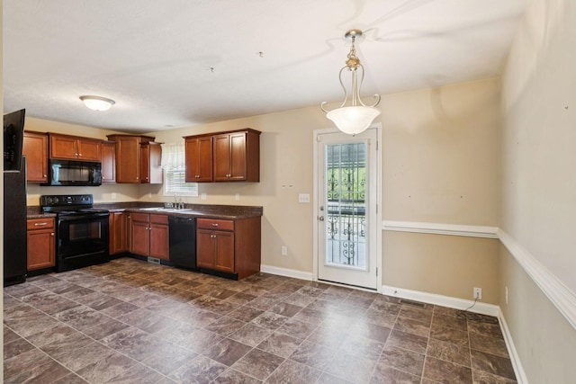 1056 Orion Jones Rd, Chapmansboro, TN 37035 - kitchen with black appliances, dark countertops, brown cabinetry, and hanging light fixtures