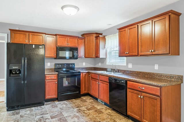 1056 Orion Jones Rd, Chapmansboro, TN 37035 - kitchen featuring black appliances, dark countertops, brown cabinetry, and stone finish floors
