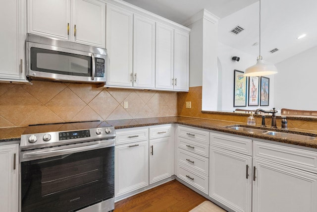 309 Seven Springs Way Unit 404, Brentwood, TN 37027 - kitchen with appliances with stainless steel finishes, a sink, white cabinetry, dark stone counters, and pendant lighting
