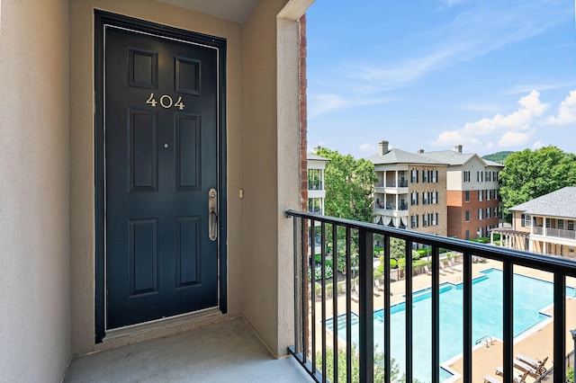 309 Seven Springs Way Unit 404, Brentwood, TN 37027 - property entrance featuring a balcony, stucco siding, and a community pool