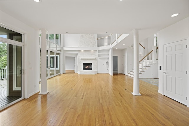 1853 Lafever Ridge Rd, Silver Point, TN 38582 - unfurnished living room with light wood-style floors, ornate columns, stairs, baseboards, and recessed lighting