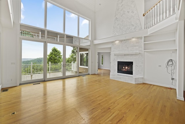1853 Lafever Ridge Rd, Silver Point, TN 38582 - unfurnished living room with a high ceiling, a brick fireplace, wood finished floors, and baseboards