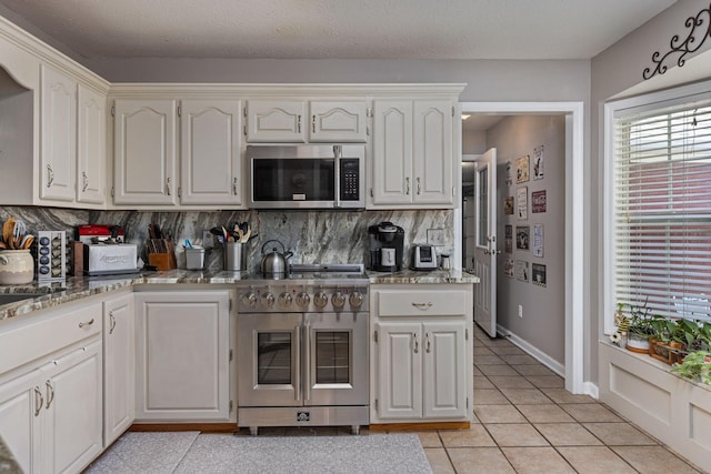 154 Jasons Way, Leoma, TN 38468 - kitchen with appliances with stainless steel finishes, decorative backsplash, light tile patterned floors, and white cabinetry