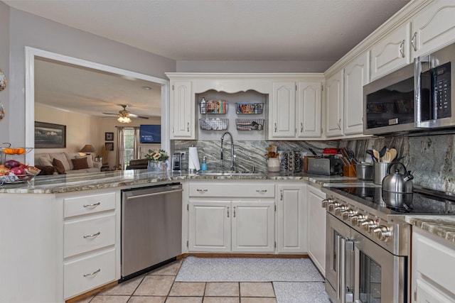 154 Jasons Way, Leoma, TN 38468 - kitchen with appliances with stainless steel finishes, a sink, light stone counters, backsplash, and light tile patterned floors