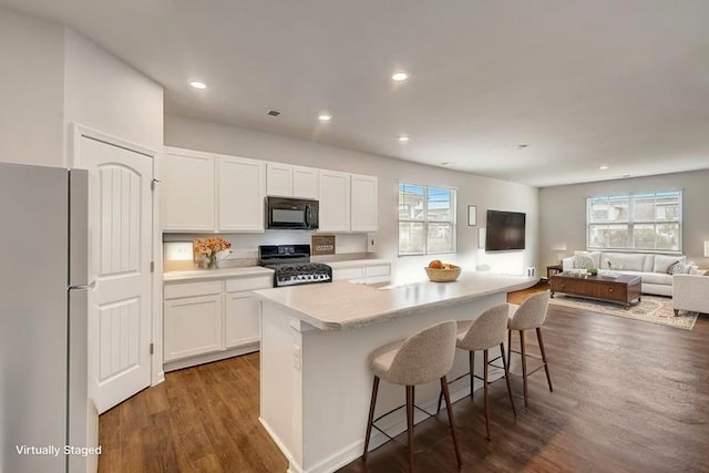 18 Pointer Pl, Lebanon, TN 37087 - kitchen with freestanding refrigerator, range, black microwave, dark wood-type flooring, and white cabinetry