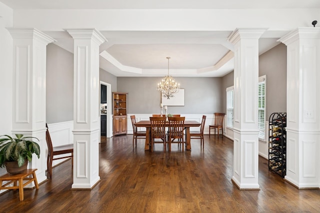 119 Abercairn Dr, Franklin, TN 37064 - dining room with ornate columns, dark wood-style floors, a tray ceiling, a decorative wall, and a wainscoted wall