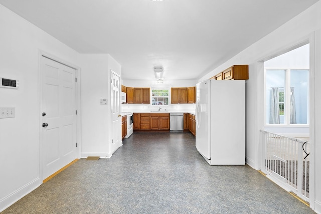 2520 Johnson Ridge Rd, Antioch, TN 37013 - kitchen featuring white appliances, brown cabinets, a sink, and baseboards