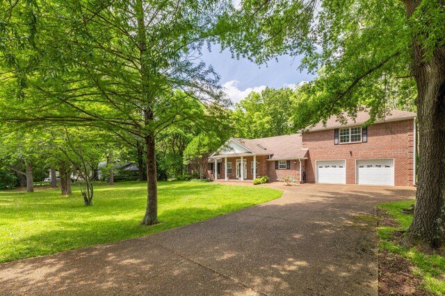 2520 Johnson Ridge Rd, Antioch, TN 37013 - view of front of home with driveway, brick siding, a front lawn, and an attached garage
