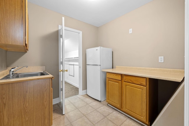 2520 Johnson Ridge Rd, Antioch, TN 37013 - kitchen featuring freestanding refrigerator, a sink, light countertops, baseboards, and brown cabinets