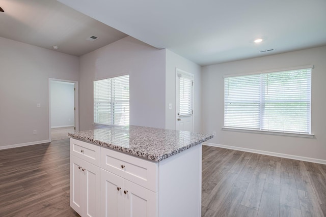 1003 Autumnwood Dr, Dickson, TN 37055 - kitchen featuring dark wood-style flooring, white cabinets, light stone counters, and a kitchen island