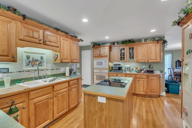 4090 Ironwood Dr, Greenbrier, TN 37073 - kitchen with white appliances, a sink, light wood-style flooring, a center island, and light countertops