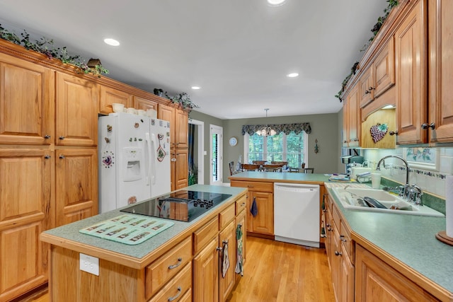4090 Ironwood Dr, Greenbrier, TN 37073 - kitchen featuring white appliances, a sink, light countertops, light wood-style floors, and a peninsula