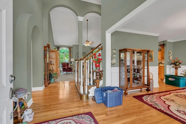4090 Ironwood Dr, Greenbrier, TN 37073 - entryway featuring light wood finished floors, arched walkways, a wainscoted wall, stairs, and a ceiling fan