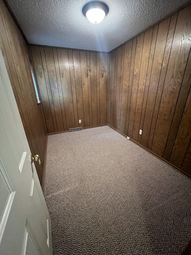 212 N 3rd St, Pulaski, TN 38478 - carpeted spare room featuring a textured ceiling and wooden walls