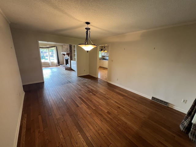 212 N 3rd St, Pulaski, TN 38478 - unfurnished dining area with dark wood finished floors, a textured ceiling, ornamental molding, baseboards, and a brick fireplace
