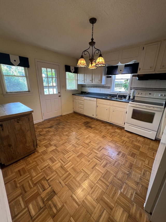 212 N 3rd St, Pulaski, TN 38478 - kitchen with white appliances, a sink, dark countertops, a textured ceiling, and hanging light fixtures