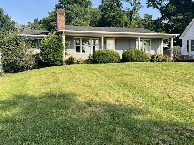212 N 3rd St, Pulaski, TN 38478 - view of front facade with board and batten siding, a front lawn, a chimney, and roof with shingles