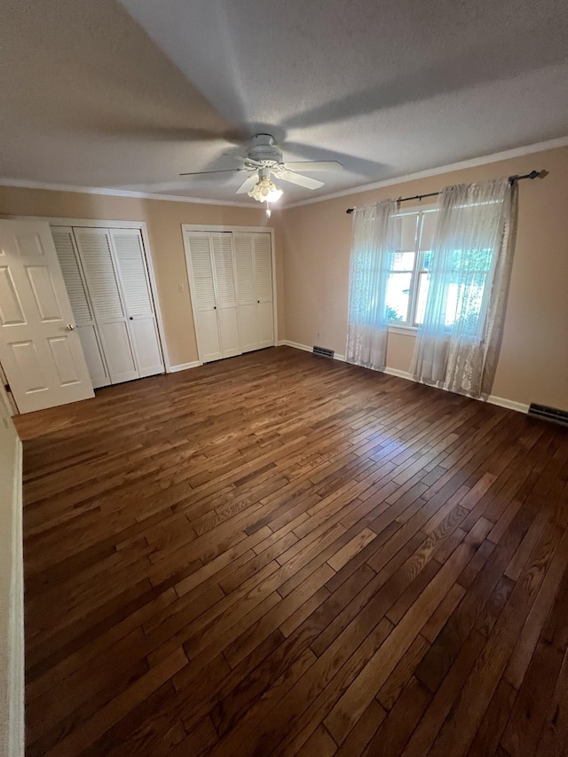 212 N 3rd St, Pulaski, TN 38478 - unfurnished bedroom with dark wood-type flooring, crown molding, two closets, baseboards, and a ceiling fan