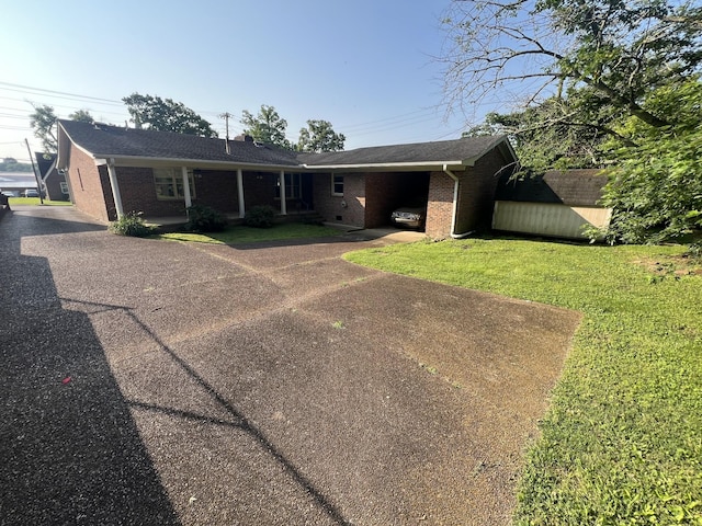 212 N 3rd St, Pulaski, TN 38478 - view of front of house with brick siding, a front yard, driveway, and an attached carport