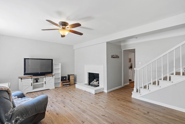 1618 Woodside Dr, Lebanon, TN 37087 - living room featuring ceiling fan, wood finished floors, stairway, a fireplace, and baseboards