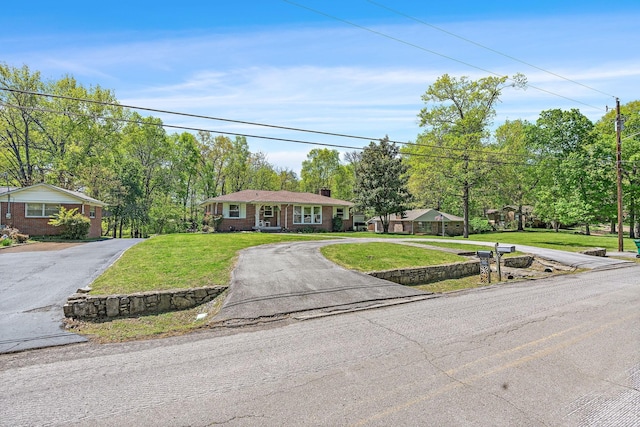1618 Woodside Dr, Lebanon, TN 37087 - single story home with curved driveway, a chimney, a front lawn, and view of scattered trees