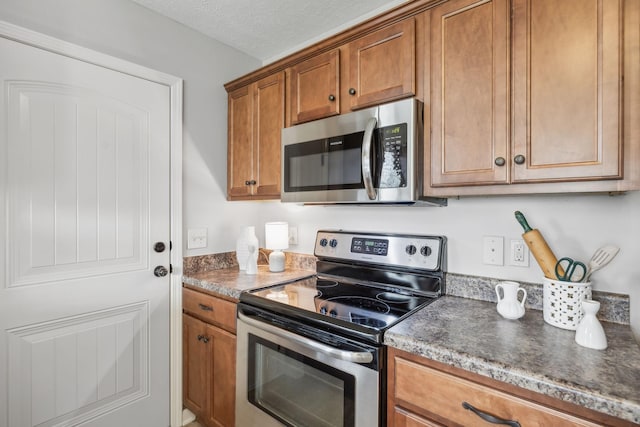 4219 Zephyr Ct, Murfreesboro, TN 37128 - kitchen featuring appliances with stainless steel finishes, brown cabinetry, and dark countertops