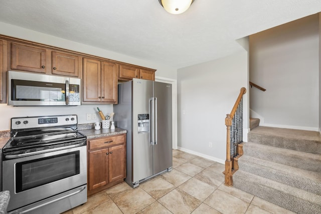 4219 Zephyr Ct, Murfreesboro, TN 37128 - kitchen with appliances with stainless steel finishes, brown cabinetry, light tile patterned flooring, and baseboards