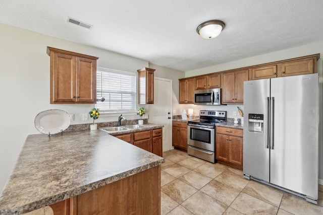 4219 Zephyr Ct, Murfreesboro, TN 37128 - kitchen with stainless steel appliances, a sink, brown cabinets, dark countertops, and light tile patterned floors