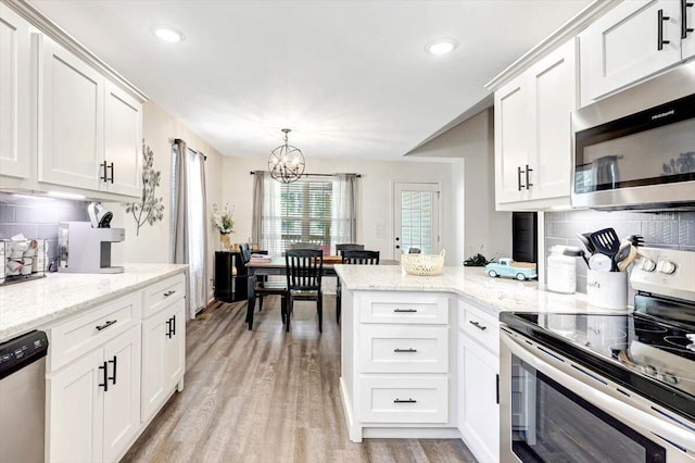 3128 Crow Rd NE, Dalton, GA 30721 - kitchen with appliances with stainless steel finishes, a chandelier, white cabinetry, a peninsula, and recessed lighting